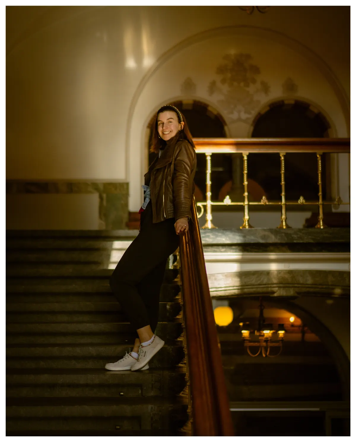 A figure on a warm-lit stairwell