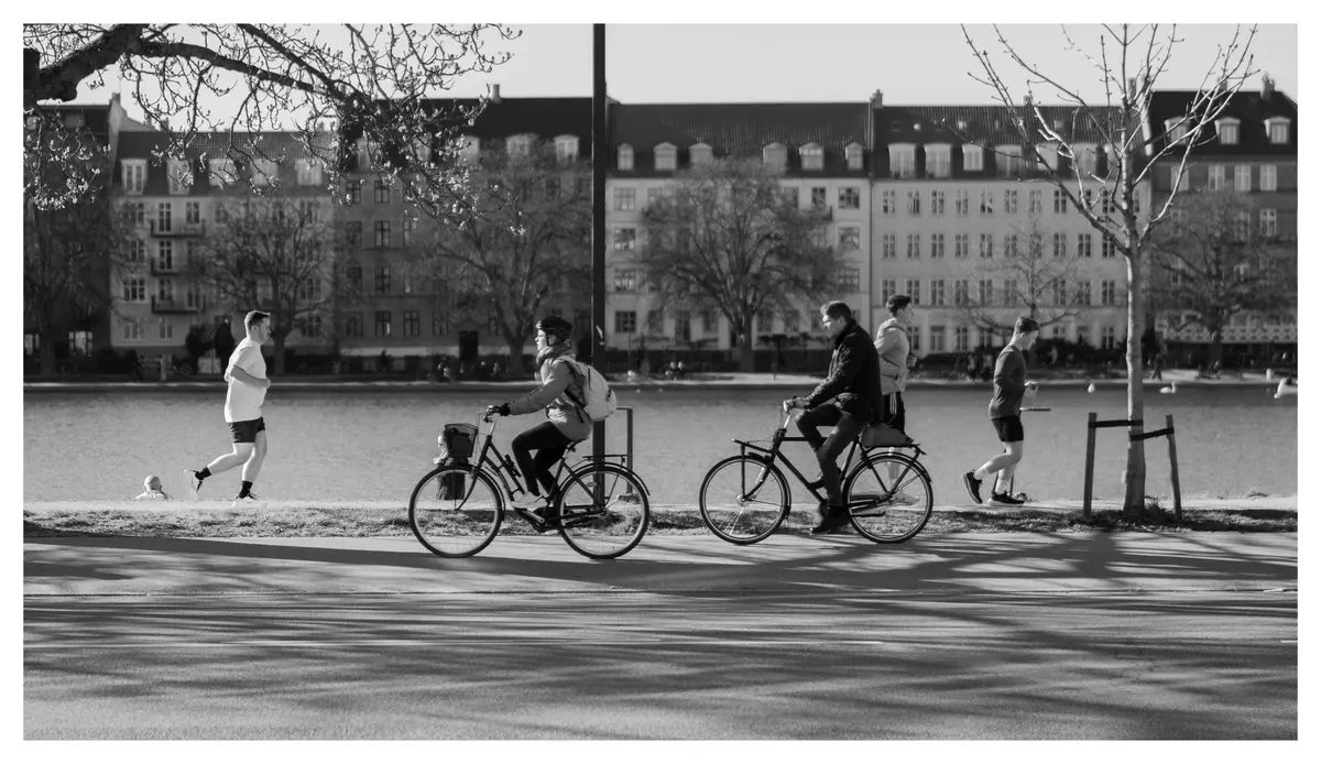 Cyclists crossing an open square, in black and white