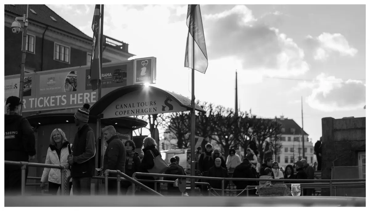 A queue at a ticket booth, in black and white