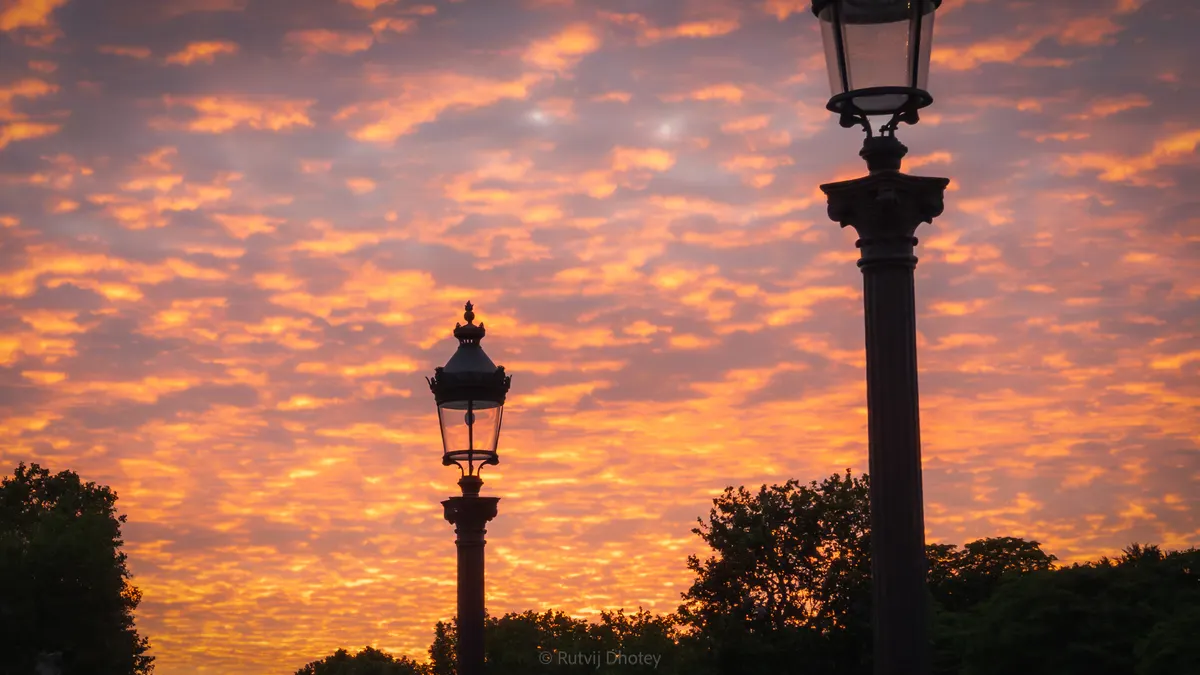 A street lamp against an orange evening sky